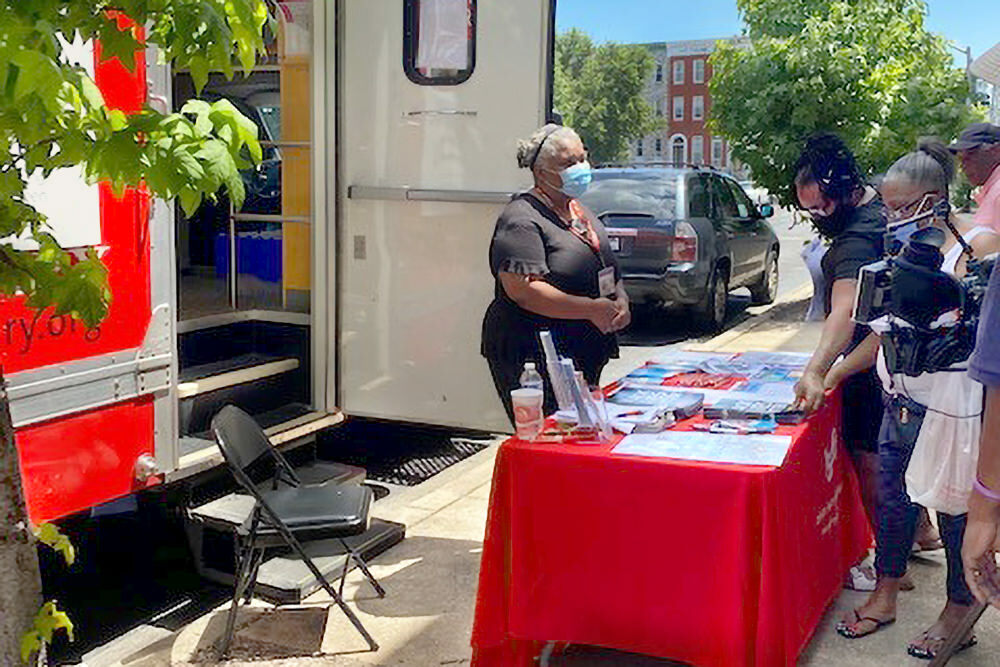 Bookmobile staff at an outdoor table in the community