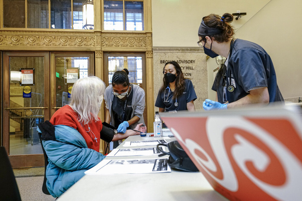 Healthcare in the Library - nurses taking blood pressure at a Central Library table