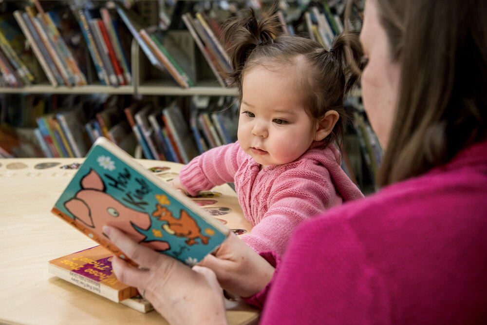 Pratt Library storytime - a young child and parent reading a book