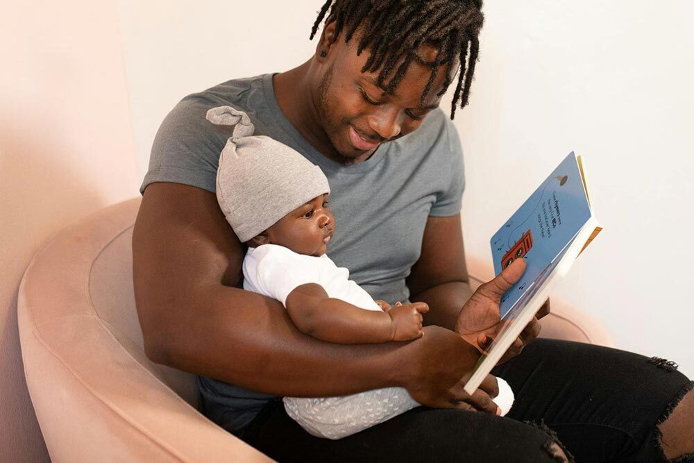 Young Children - baby and father looking at a children's book