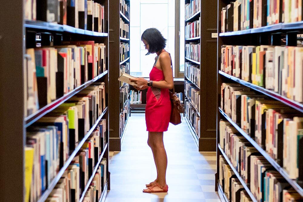 Browsing bookshelves at Central Library - a woman between bookshelves holding a book