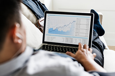 business man on laptop with analytics screen at home