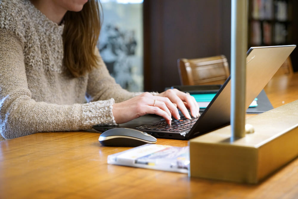 woman typing on her laptop at Pratt Library