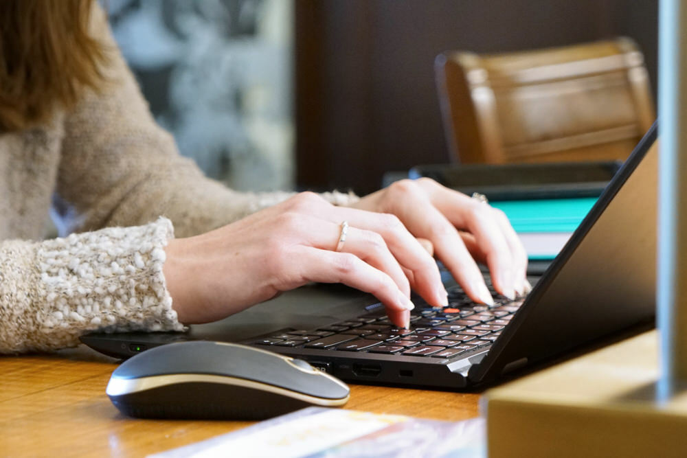 woman using a laptop at a Pratt Library table