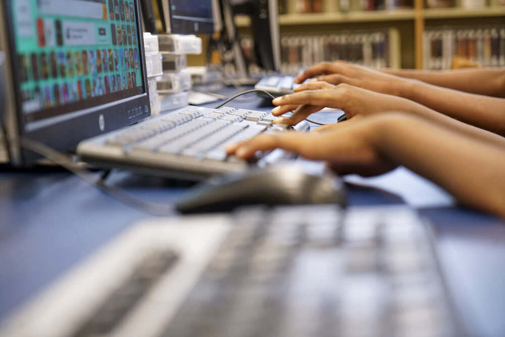 Computers - people's hands using keyboards at a Pratt Library