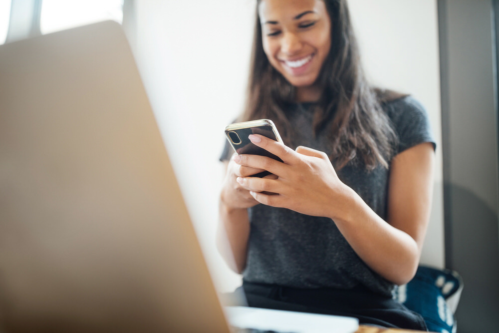 Live Chat with a Librarian - woman using a phone and laptop