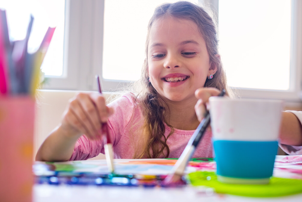 girl smiling while painting - after school art and crafts