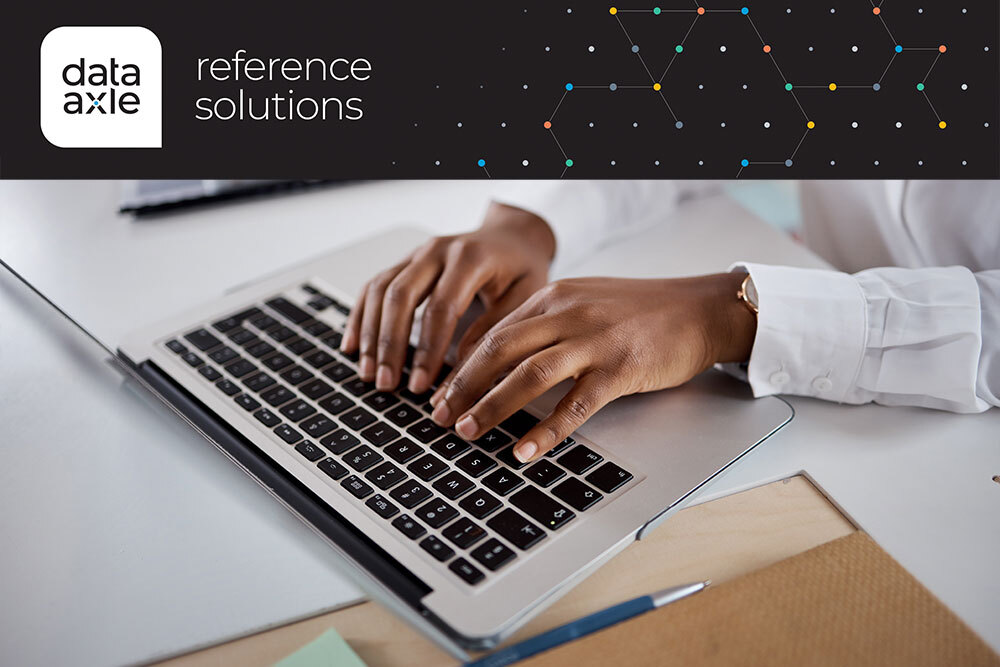 DDataAxle reference - logo and white pages database graphics and hands using a laptop