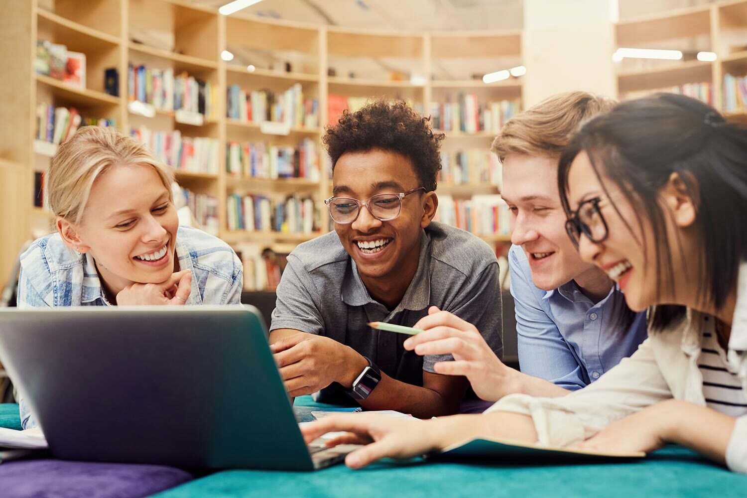 Teens in library watching video on computer