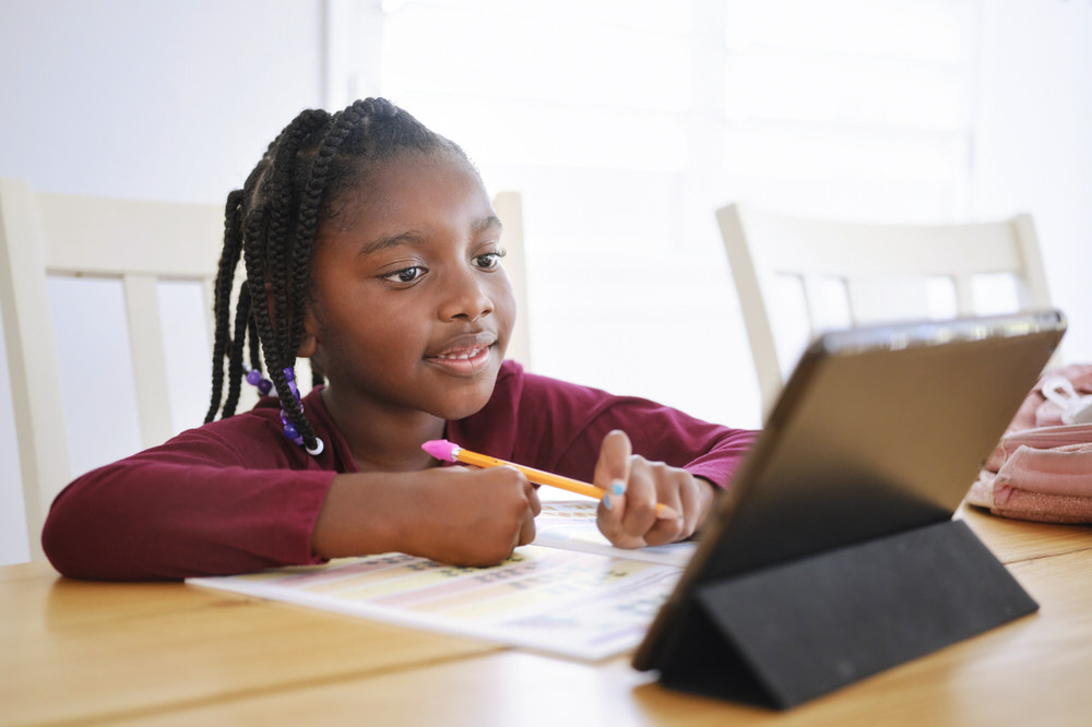kids homework - young girl with workbook, pencil, digital tablet