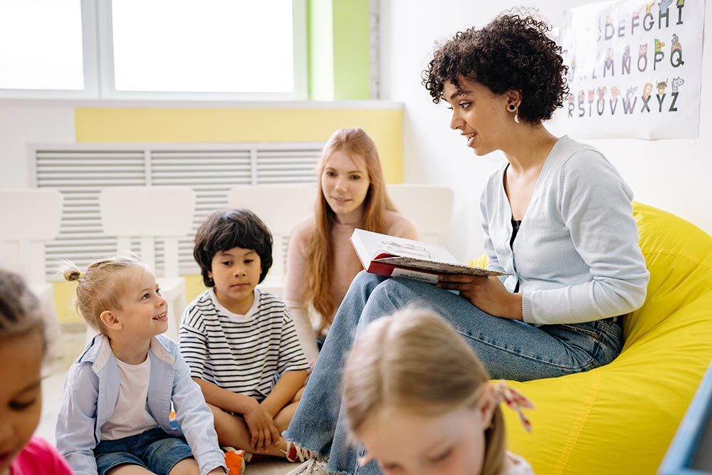 storytime events for young children showing kids, adults, and an alphabet on the wall.
