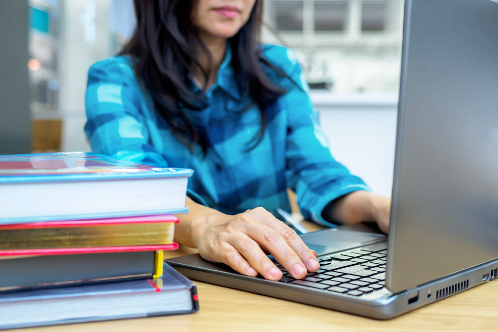 Internet Use - woman with laptop and books