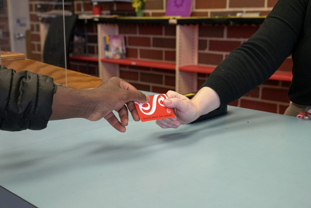 getting a library card at the desk of a Pratt Library branch