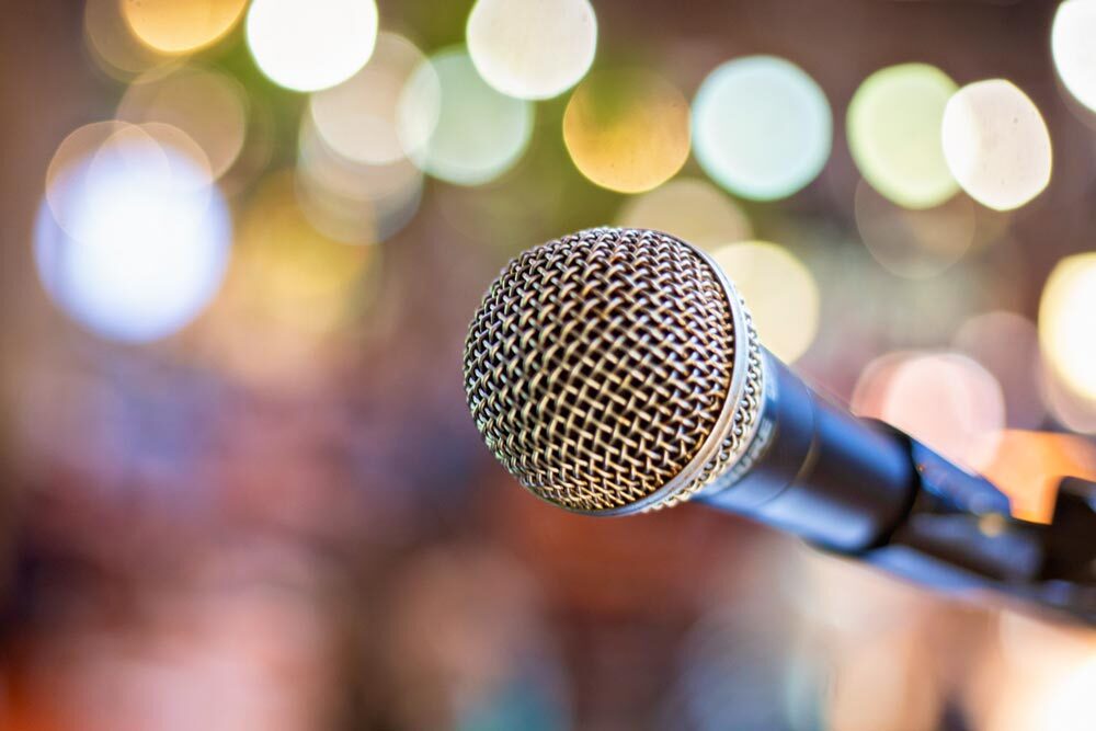 speakers - microphone on a stand blurred background lights