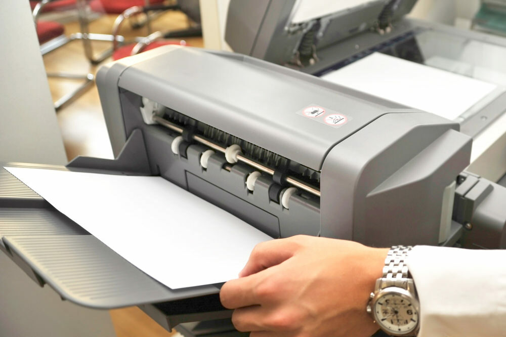 printer or copier - hand reaching for paper