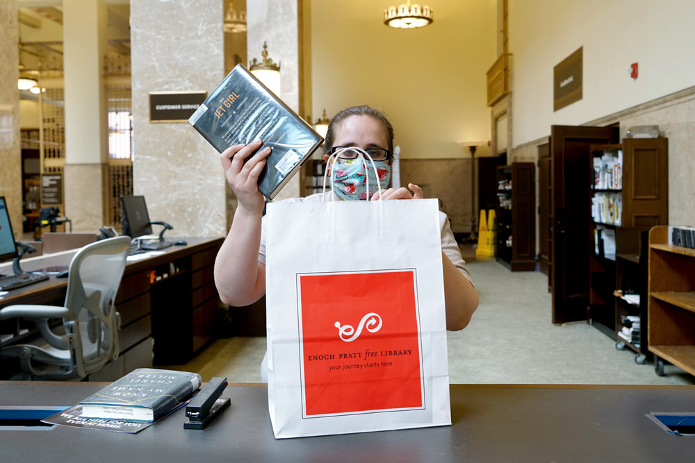 Sidewalk Service - staff getting a bag of library materials ready for pickup