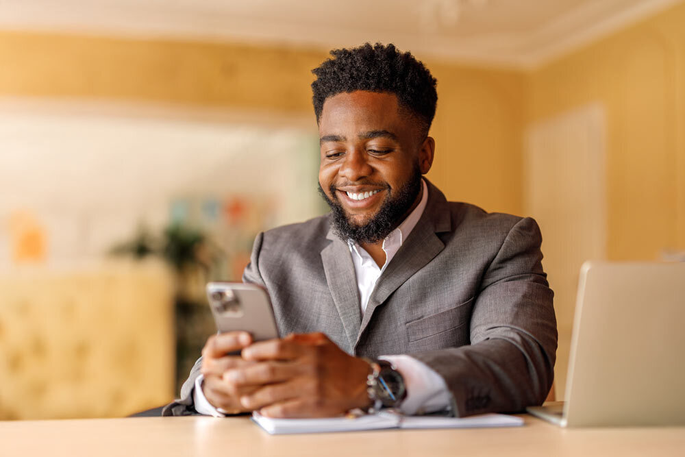 man in suit texting at a table
