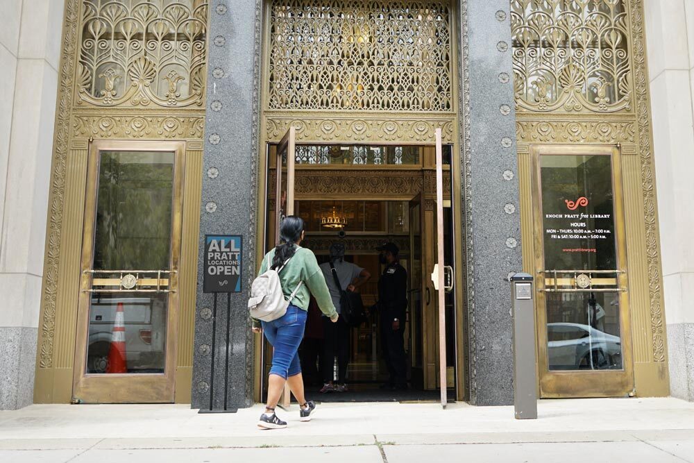 visit the library - a person entering front doors of Central Library