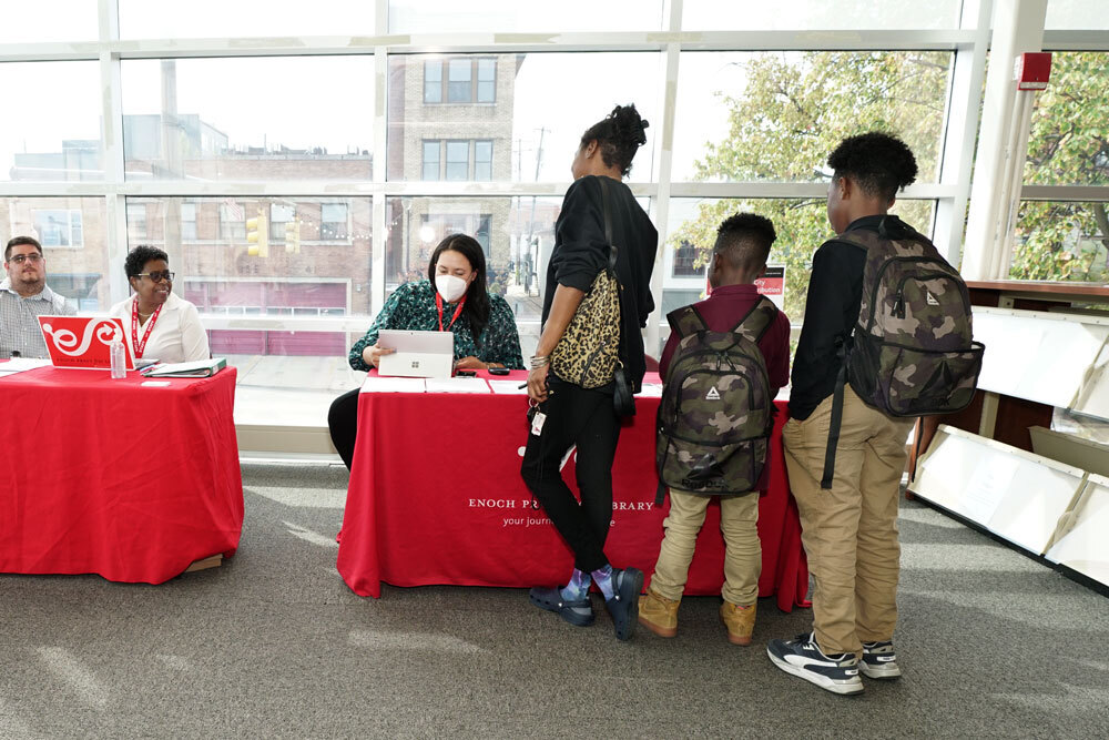 family and staff at HP Chromebooks distribution at Pratt Library tables