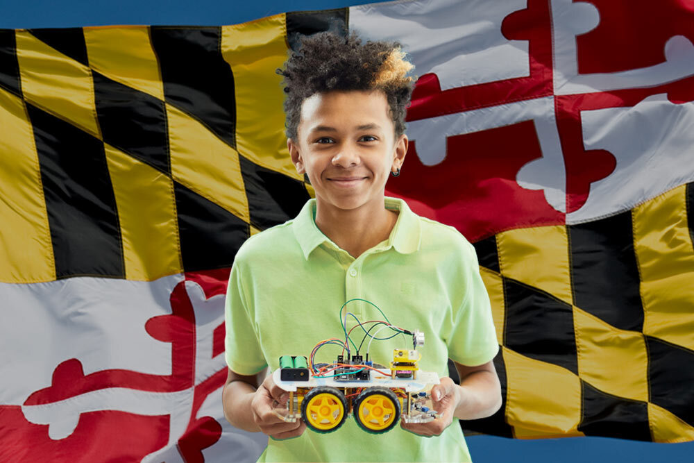 MD STEM Festival - STEAM boy holding robotics with Maryland flag in the background