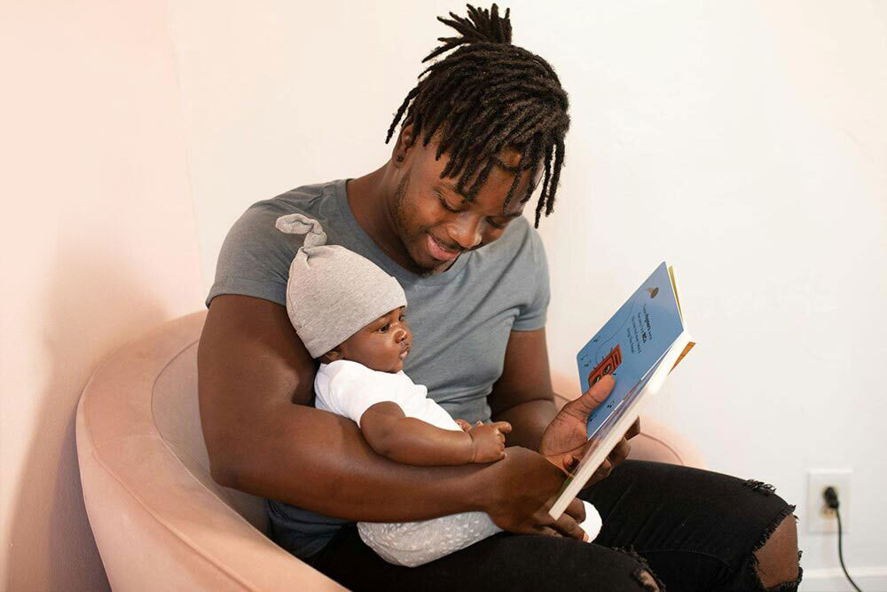 Young Children - baby and father looking at a children's book