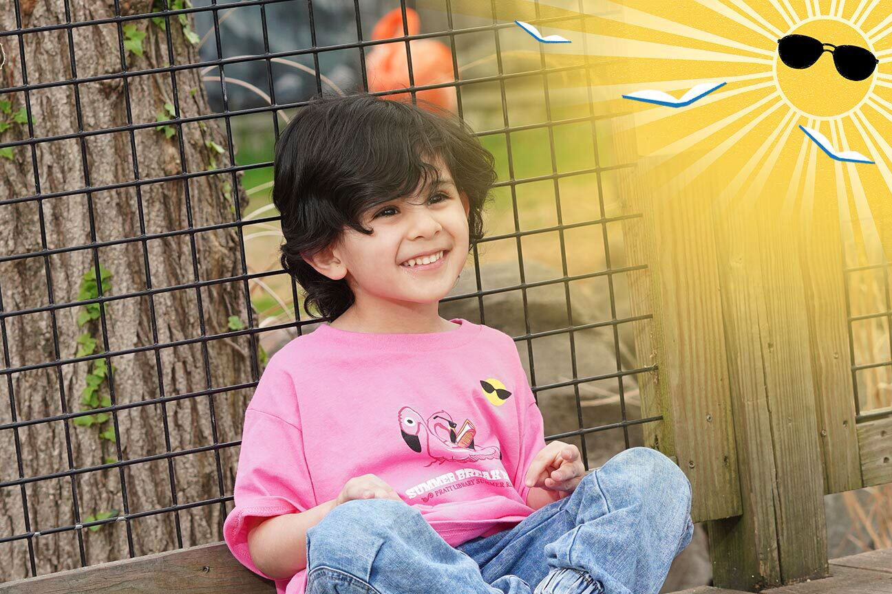 Summer Break Baltimore child wearing a 2025 t-shirt at the zoo with sun and flying books logo