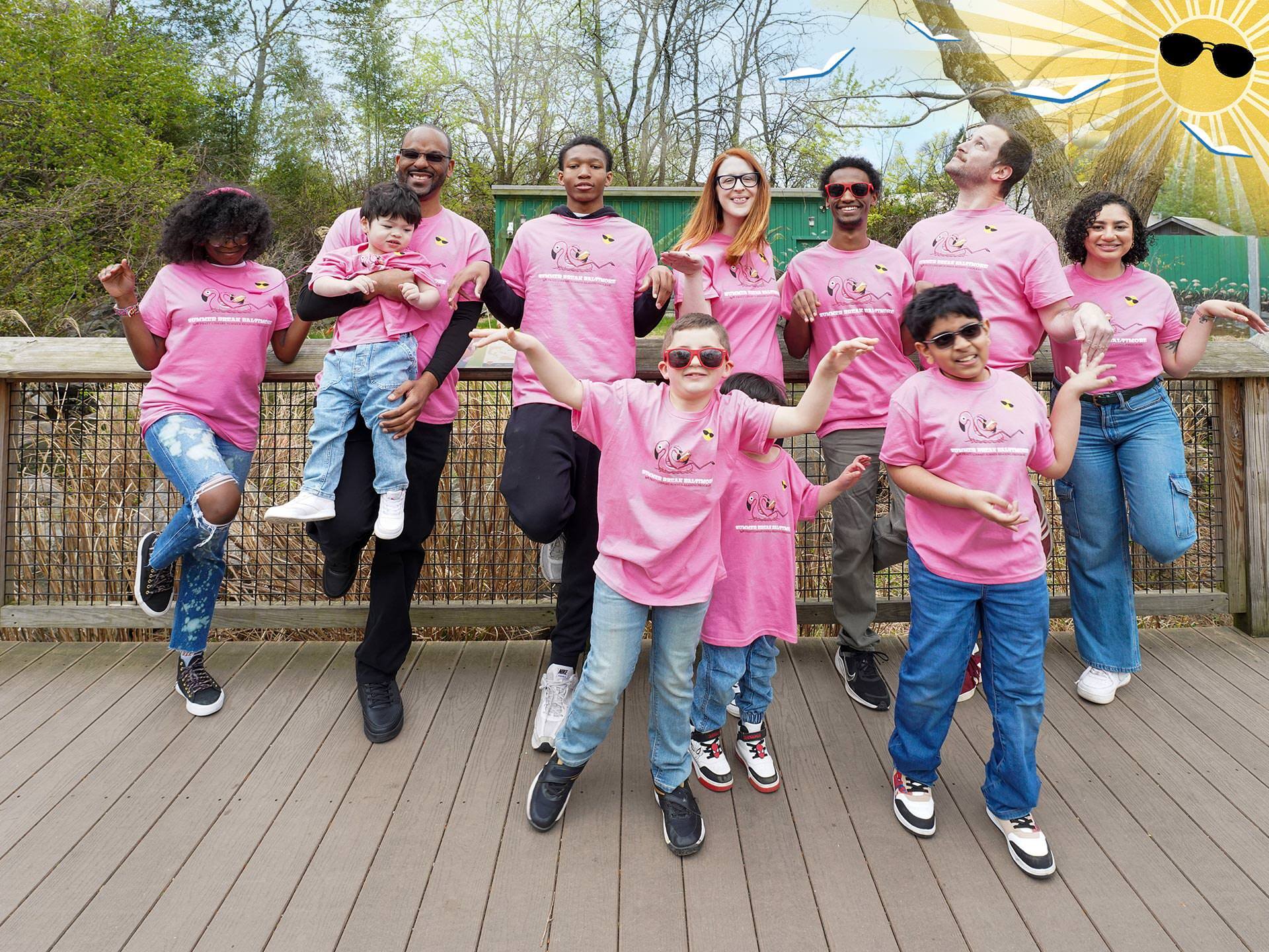 Summer Break Baltimore group of people in their 2025 t-shirts at the zoo with sun and flying books logo
