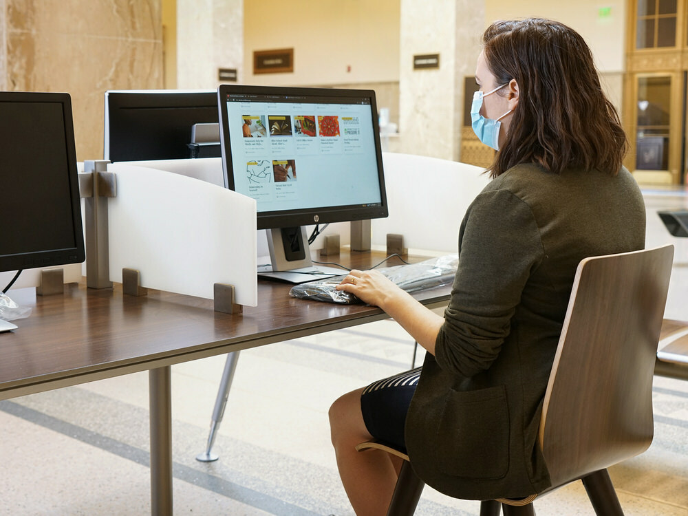 using a computer at the libraru while wearing a face mask