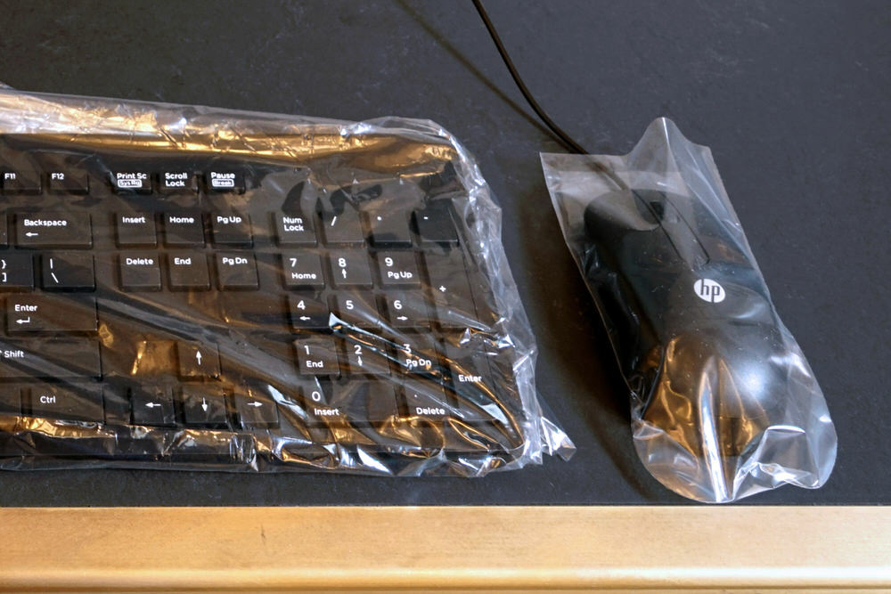 computer keyboard and mouse under plastic for safety
