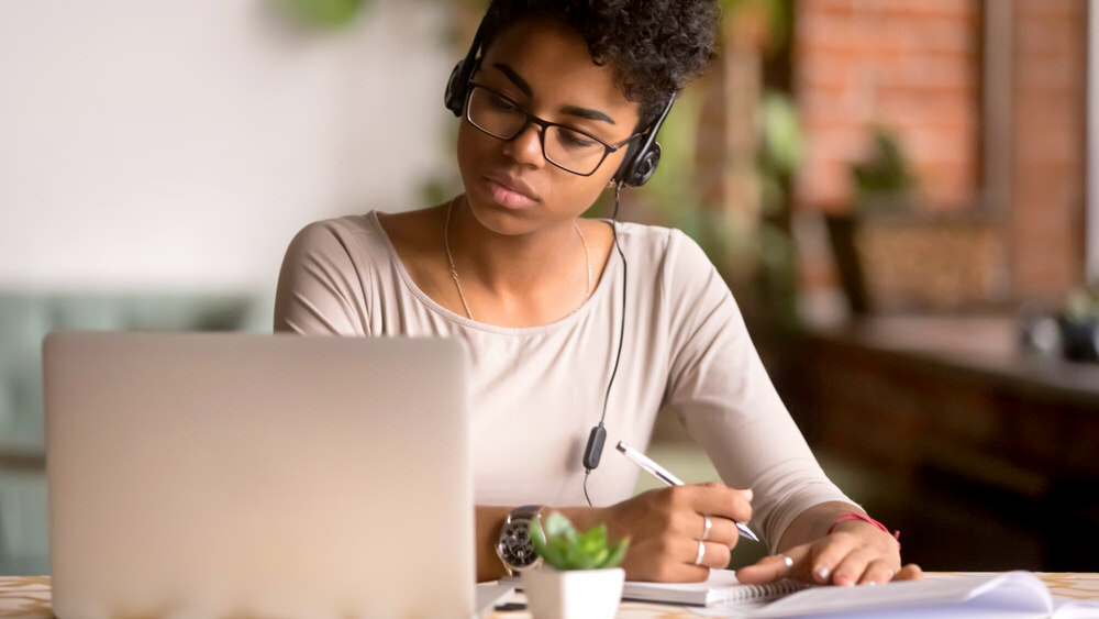 serious woman studying with a laptop and notebook