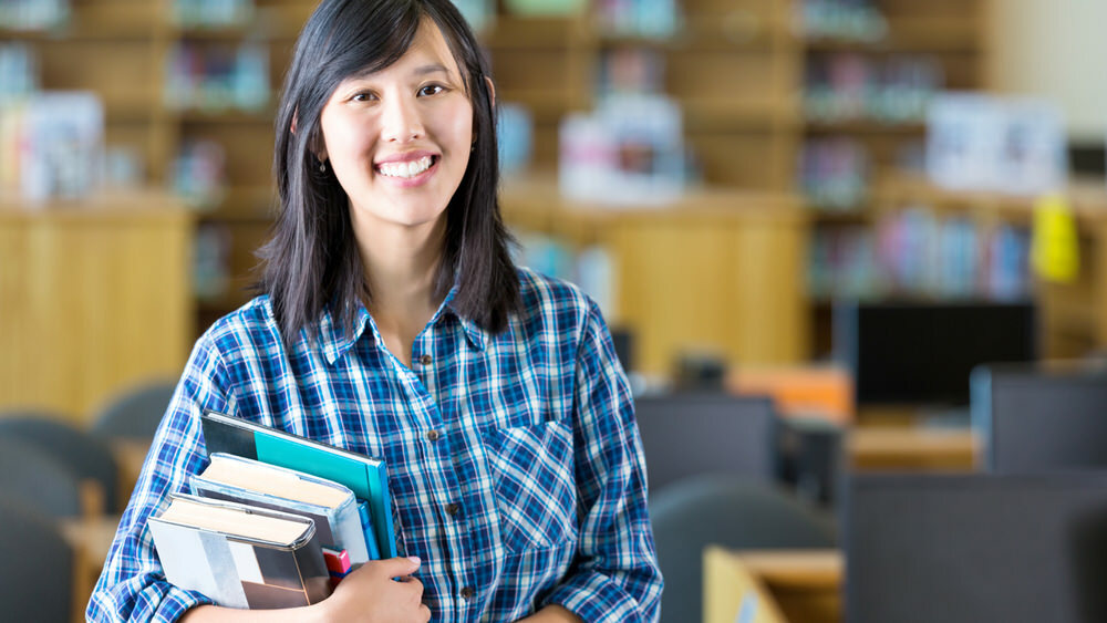 teacher in her classroom with library books