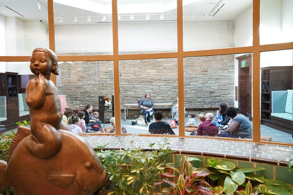 Children's Department - fish pond and sculpture with a storytime event visible in the room beyond