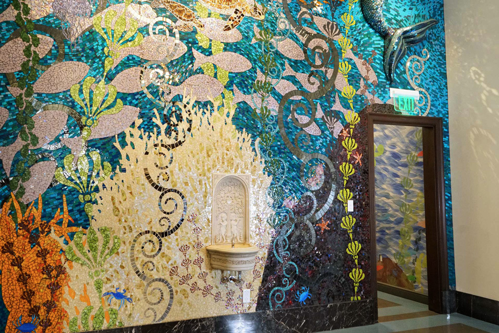 Children's Department - a fish themed mosaic and vintage water fountain on a wall by the exit