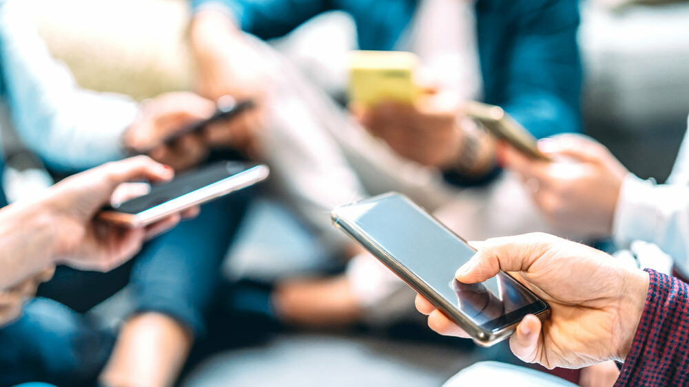 group of people with phones, spreading fake news