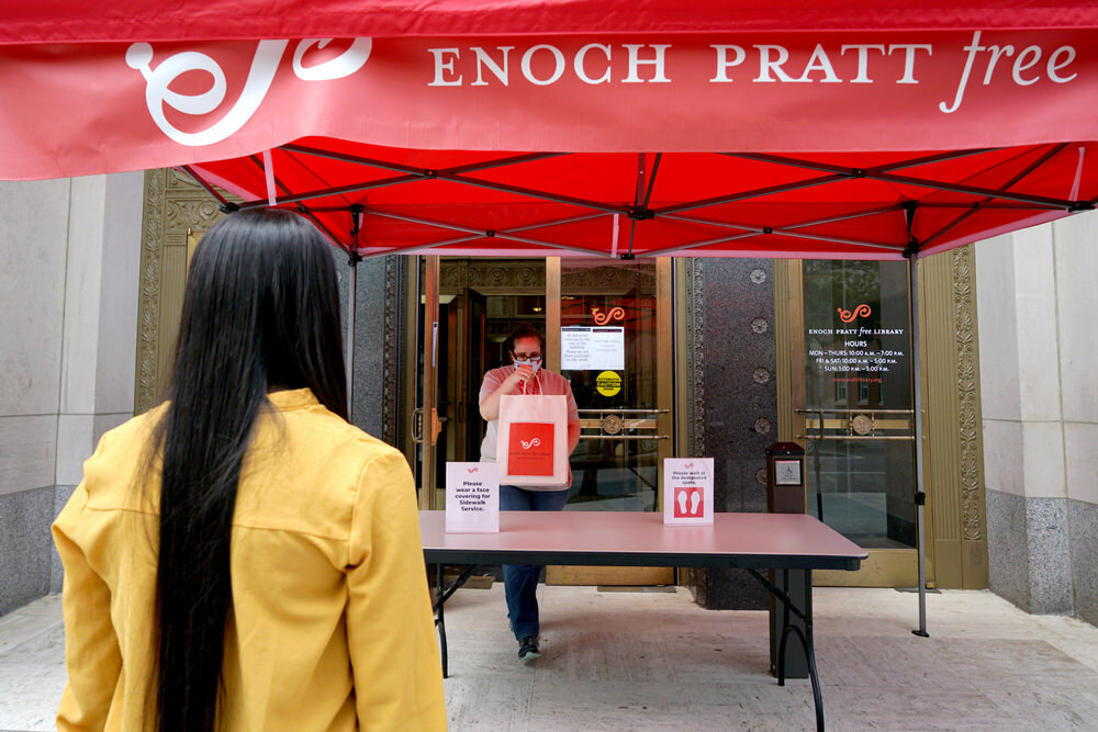 Sidewalk Service - customer and staff by table tent at Central Library