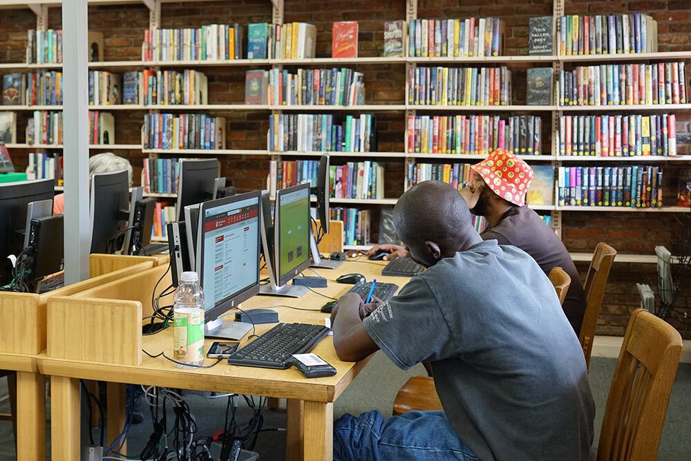 Public computers - two adults at tables using computers at a library branch