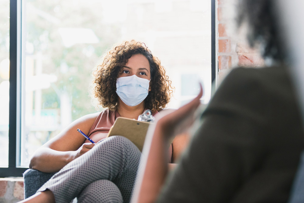 social worker with mask, listening to a customer