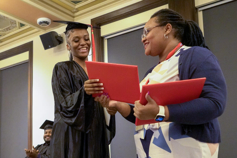 a graduate receiver her diploma from Career Online High School at Pratt Library