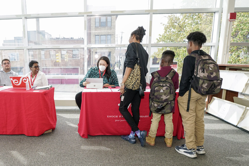 Chromebook distribution at the library - a family signing up to get their Chromebook