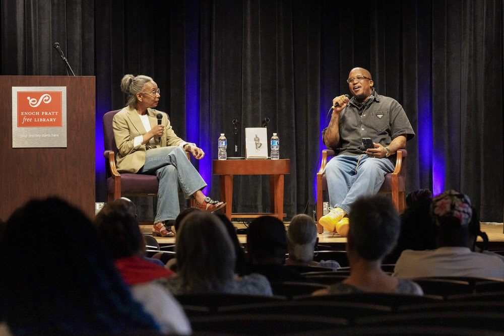 D Watkins on stage speaking at the Pratt Library