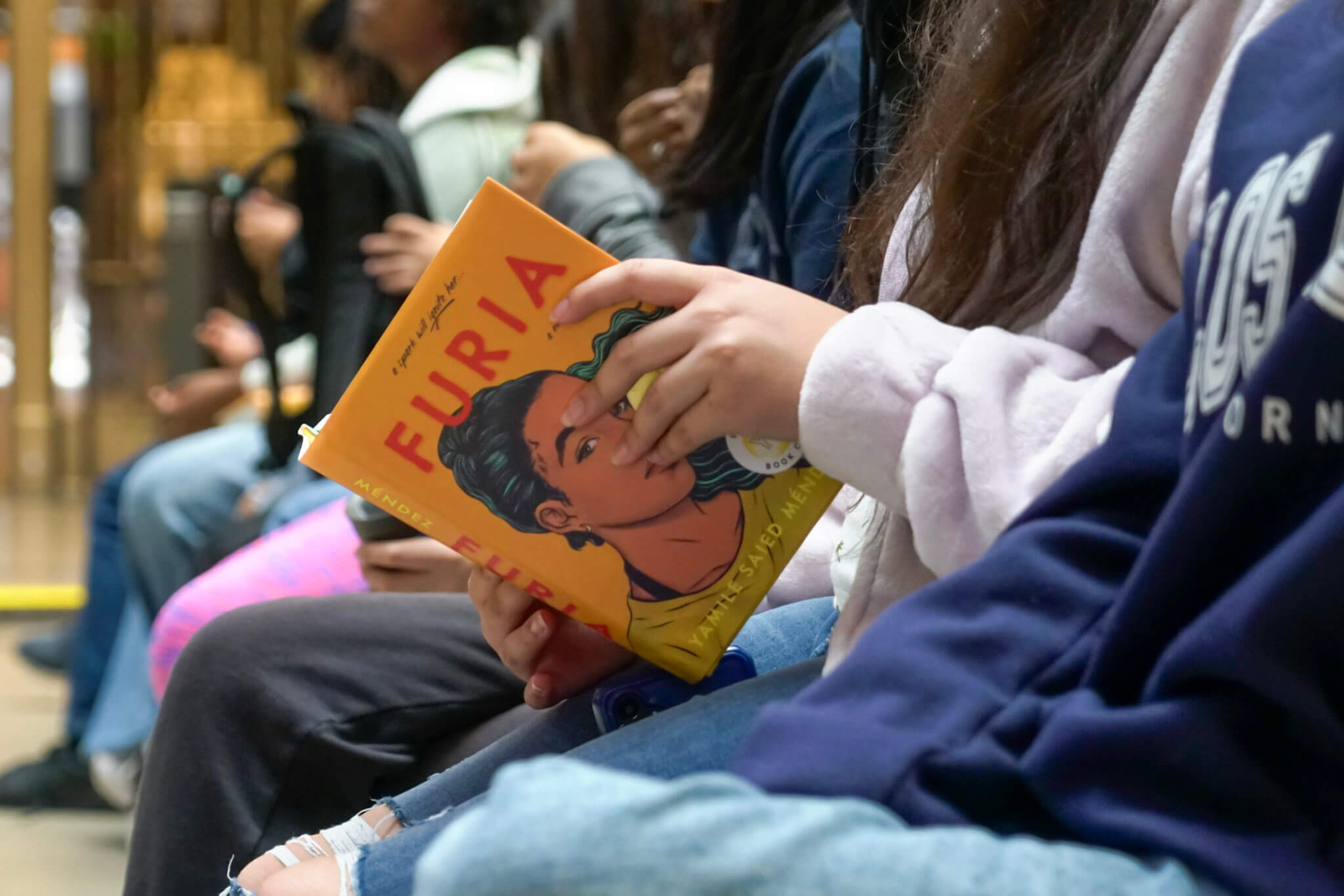 A reader holding Furia by Author Yamile Saied Méndez