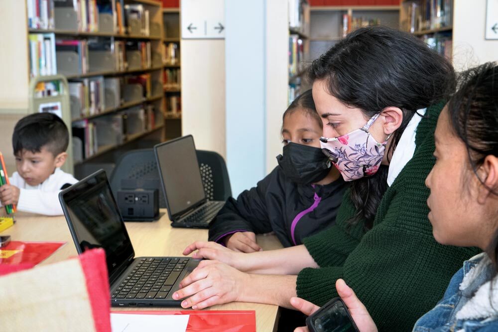 a family at Orleans Street Branch using their new Dell chromebook laptops