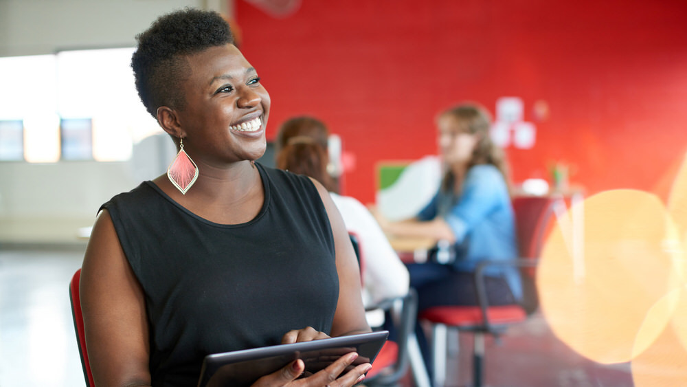 Entrepreneur Academy - a confident, smiling woman with a digital tablet