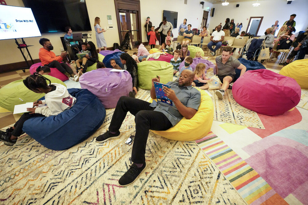 Imagination Celebration 2025 - families drawing on beanbag chairs