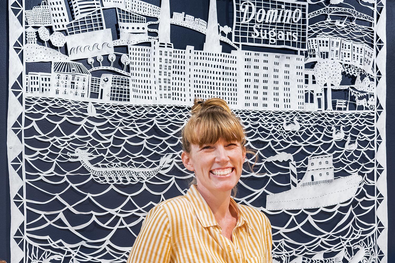 Annie Howe closeup with her papercut artwork in the background