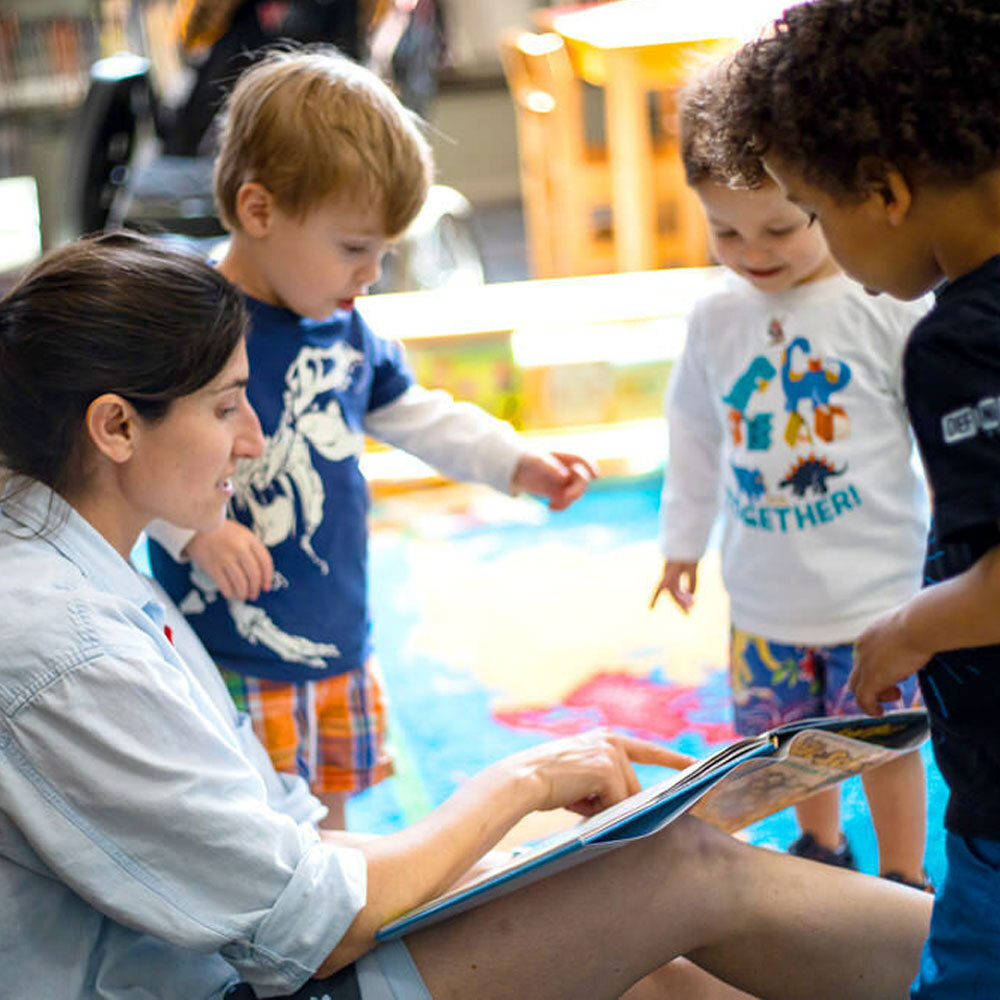 Librarian with young children and a book