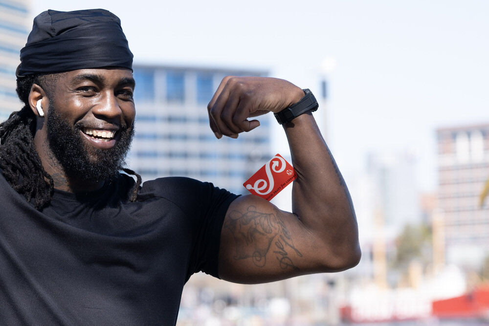 smiling man flexing with a Pratt Library card.
