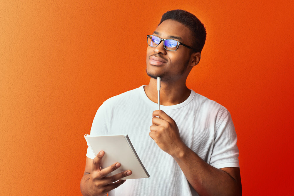 Maryland man with pen and notebook, thinking about the poetry contest