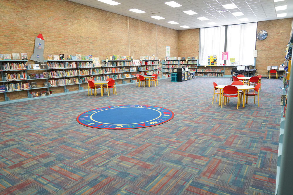 Brooklyn room showing children's area with chairs, colorful rug, an d books for kids