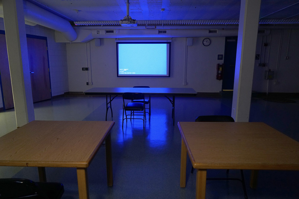 Edmondson Avenue Meeting Room - projection screen in the dark, tables, chairs
